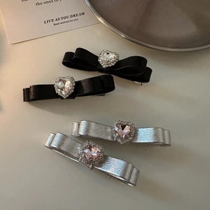 Elegant bow hair clips set with heart-shaped zircon stones and leather-style ribbon textures