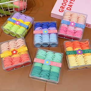 Set of colorful elastic hair bands in six storage boxes with soft macaron candy colors