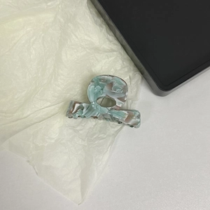 Detail of marbled mint green acetate hair claw clip with golden Barrette France logo