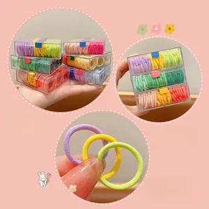 Macro shot of colorful high-elastic hair ties in a clear storage box for girls' ponytails