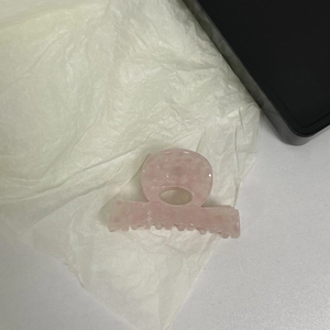 Detail of pink marble acetate hair claw clip showing a hollow semi-circular design