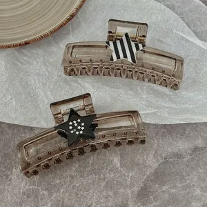 Large star-shaped hair claw clip in dark coffee brown with decorative star patterns