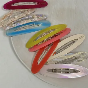 Colorful acetate BB hair clips set with marbled patterns in a white ceramic dish