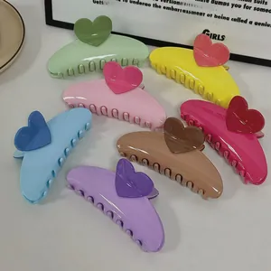 Detailed view of large cream-colored heart hair claws in seven assorted macaron colors