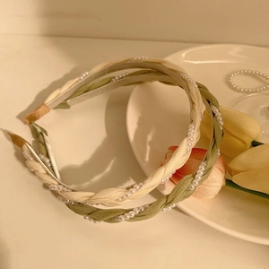 Braided pearl headbands in cream white and sage green with elegant floral background
