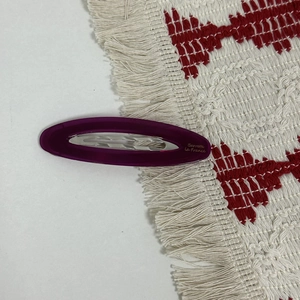 Detailed view of a purple oval acetate hair clip with gold Barrette La France lettering