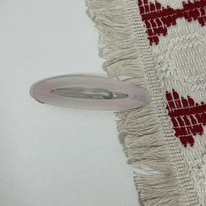 Macro shot of the Barrette La France lettering on a pink oval acetate hair clip
