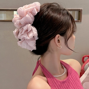Detail eines rosa geschichteten Organza-Haargummis am Modell für eine voluminöse Frisur