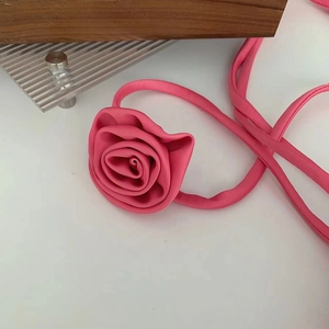 Macro di un accessorio a fiore 3D rosa acceso con lunghi nastri abbinati