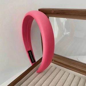 Dettaglio fascia per capelli in spugna rosa con etichetta fatta a mano su legno