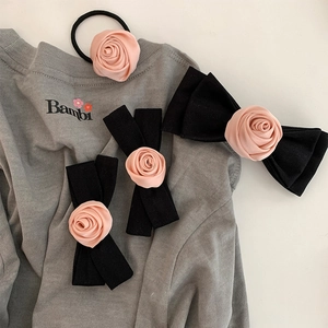 Pink satin rose hair accessories set with black bows on a stylish grey sweatshirt