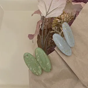 Lot de quatre barrettes ovales en résine avec texture feuille d'or en vert et bleu