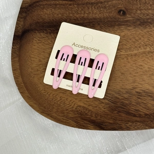 Lot de trois pinces à cheveux BB rose pastel sur une carte de présentation