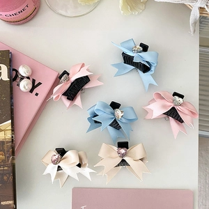 Barrettes à nœuds rose et bleu avec strass en cœur présentées sur un fond esthétique décoré
