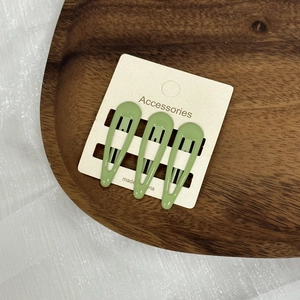 Trois barrettes BB en métal vert avocat en forme de goutte présentées sur carte