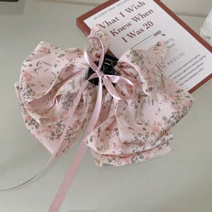 Detail of pink floral bow hair claw with silky ribbon and sturdy black plastic clip