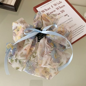 Detailed top view of a French floral tulle hair claw clip with a light blue silk ribbon bow