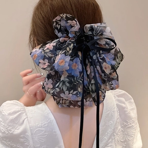 Grande pince à cheveux avec nœud floral et longs rubans noirs sur vue arrière