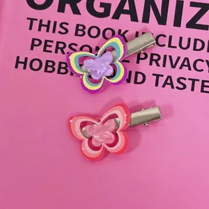 Y2K aesthetic colorful butterfly hair clips with acrylic layering on a pink book
