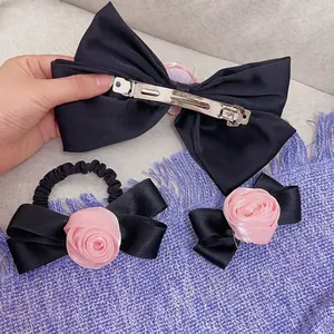 Set di fermagli per capelli in raso nero con rose di stoffa rosa dallo stile elegante