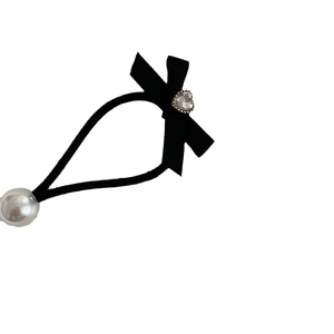 Élastique à cheveux noir avec nœud, cristal de cœur et perle sur fond blanc