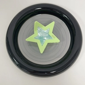 Detail of green star hair claw clip with blue marble texture and gold handmade lettering