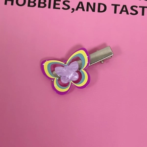 Macro detail of multilayer colorful acrylic butterfly hair clip with shimmering purple glitter