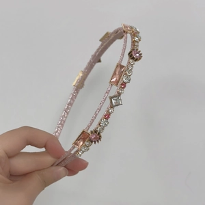 Detailed close-up of double-layered pink crystal headband with sparkling rhinestones