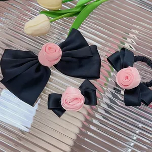 Set di fermagli per capelli con fiocchi di raso nero e rosa di stoffa su fondo argento
