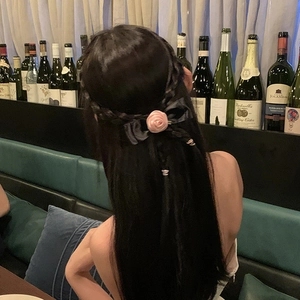 Pink fabric rose on black silk bow hair clip worn on braided hair for women