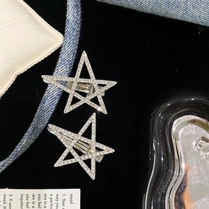 Paire de barrettes étoile Y2K scintillantes en strass argentés sur un décor denim chic