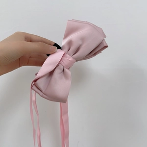 Détail d'une pince à cheveux à nœud en soie rose avec de longs rubans élégants