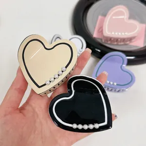 Elegant heart-shaped acetate hair claw clips with pearl accents in assorted colors