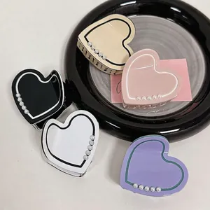Elegant heart-shaped pearl claw clips in various colors with contrasting line accents
