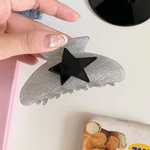 Detail view of the silver glitter star hair claw clip with a black star accent