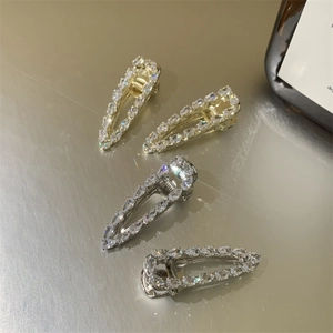 Macro detail of four French vintage hair clips with sparkling zircons on a metal surface