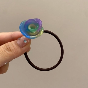 Detailed close-up of a semi-transparent gradient resin rose flower on a brown hair tie