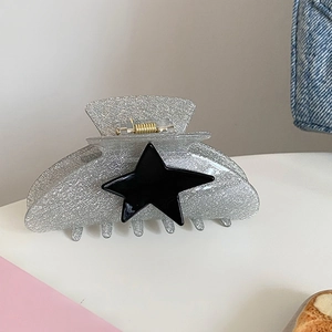 Detail of glitter hair claw clip with black star design and sturdy metal spring
