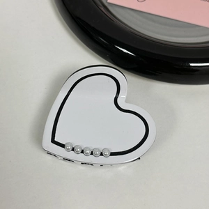 Detailed view of heart-shaped acetate hair claw clip with black edges and pearls