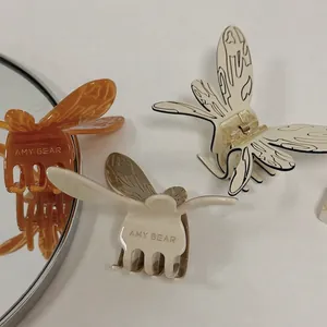 Trois pinces à cheveux papillon en acétate, motifs ambre et crème avec finition brillante