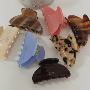 Set of seven colorful acetate hair claws in various patterns with gold lettering finish