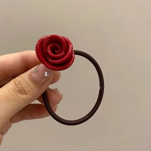 Detail of red rose resin hair tie with a durable dark brown elastic band held in hand