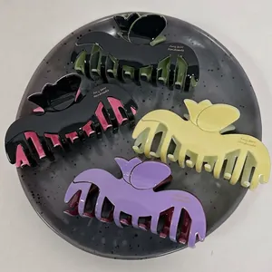 Elegant tulip-shaped acetate hair claw clips in assorted matte colors set in a tray