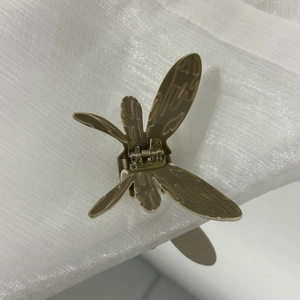 Vue détaillée de la pince à cheveux papillon avec texture marbrée et ressort en métal