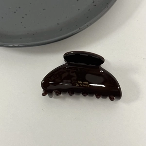 Detailed view of the glossy brown acetate hair claw with golden Barrette la France text