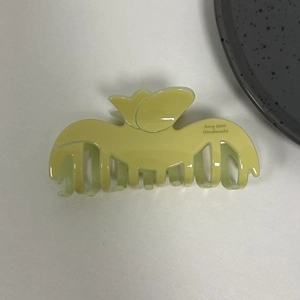 Elegant tulip-shaped acetate hair claw clip in soft light green for long hair styling