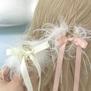 Détail d'une pince à cheveux en plumes avec long ruban sur cheveux blonds