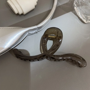 Détail macro d'une pince à cheveux grise translucide avec un design en résine élégant