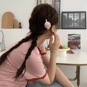 Pince à cheveux rose en tissu élégante pour femme sur une tresse dans un cadre esthétique