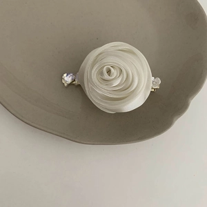 Détail d'une pince à cheveux rose en gaze blanche faite main avec strass en cœur poli